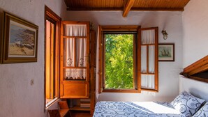 A bedroom with a bed, a window with curtains, a wooden ceiling, and a painting on the wall. - Country Villa Kalimera | Private Hilltop Villa in Skopelos with Pool & Views (skopelos)