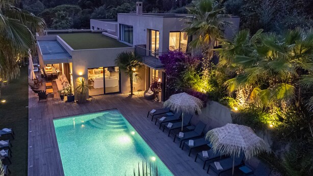 A modern house with a swimming pool, lounge chairs, and a well-lit patio area. - House / Villa - SAINT-TROPEZ (La Croix-Valmer)