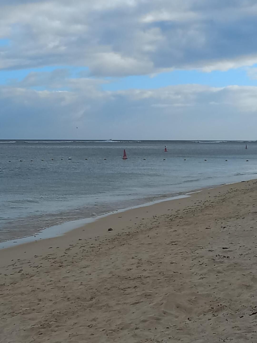 A beach with a sandy shore and calm water.