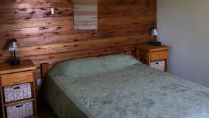 A single bed with a wooden headboard, two bedside tables with lamps, and a wall-mounted shelf.