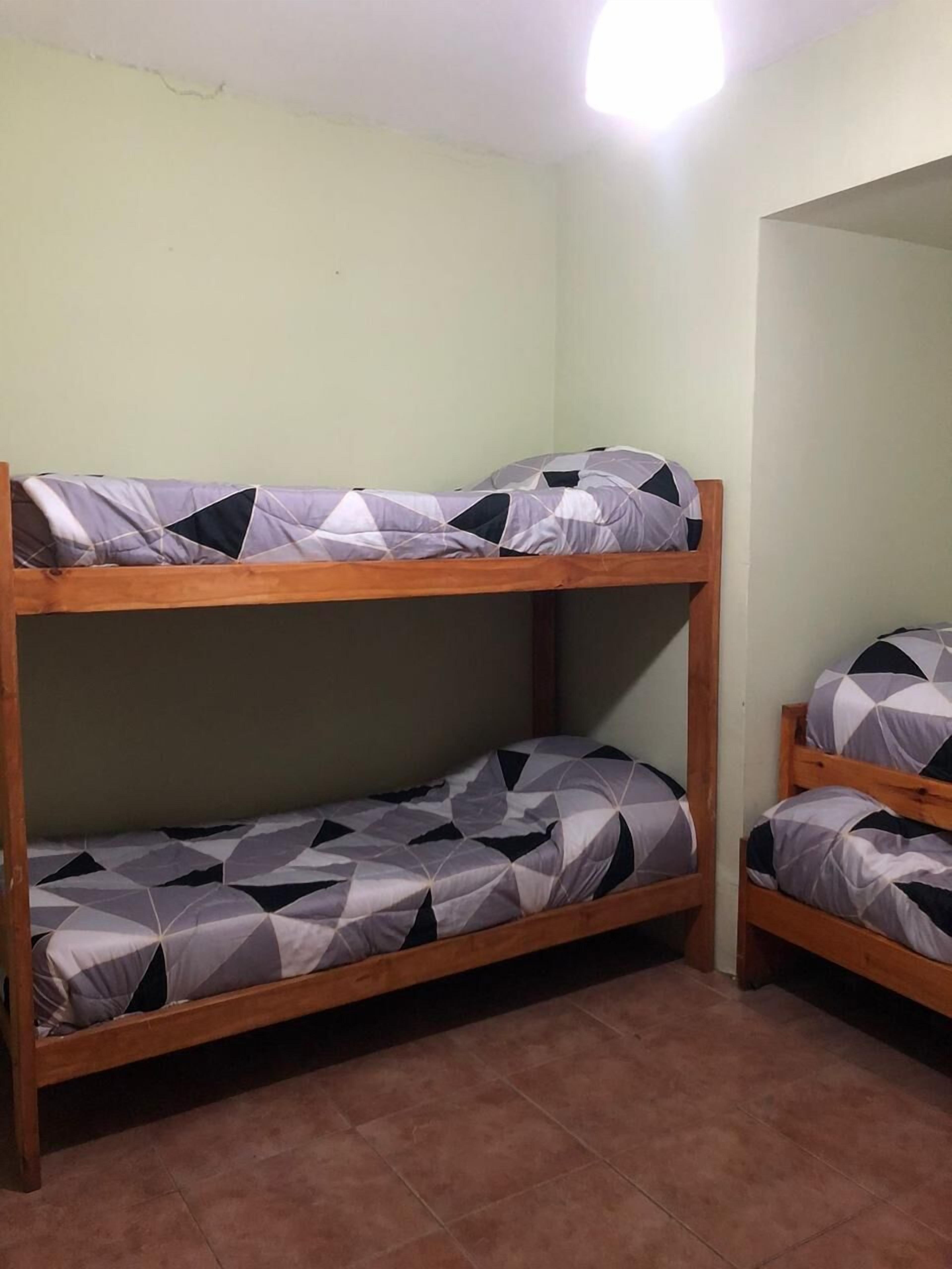 A bunk bed room with two beds, each with patterned bedding.