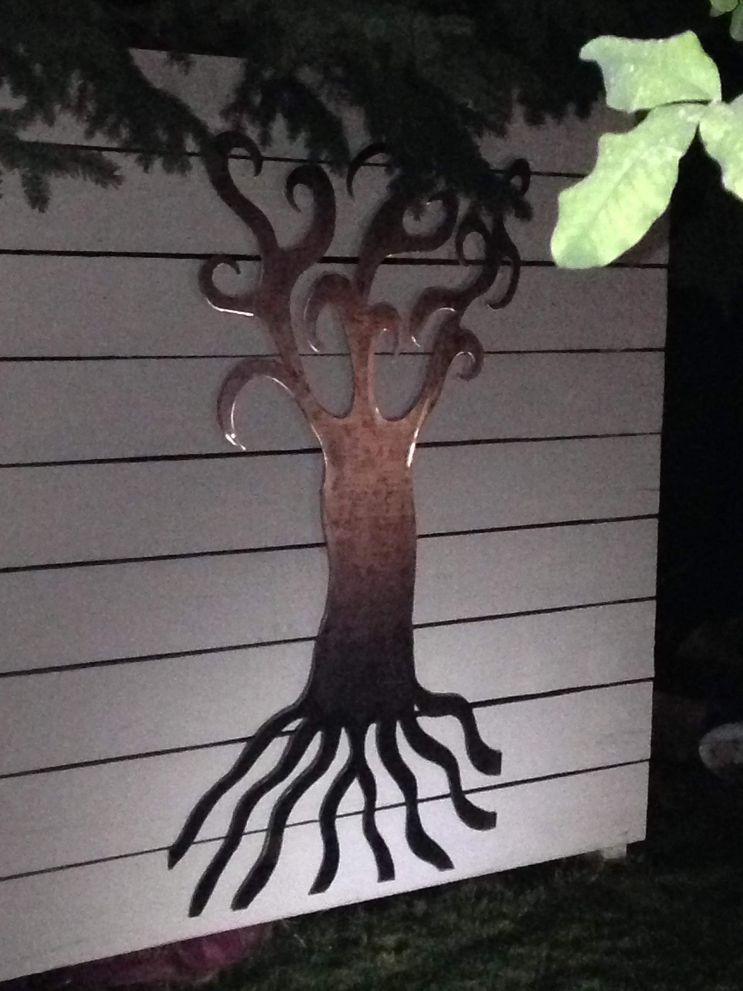 Un motif représentant un arbre, appliqué sur un mur avec des lignes horizontales.