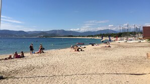 A beach with people sunbathing and swimming. - Bedroom ADVENTURE Villa AMALIA (PORTICCIO)