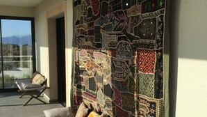 A balcony with a view of mountains, a patterned wall, and two lounge chairs. - Bedroom ADVENTURE Villa AMALIA (PORTICCIO)