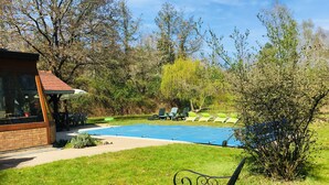 A pool area with lounge chairs and a gazebo.