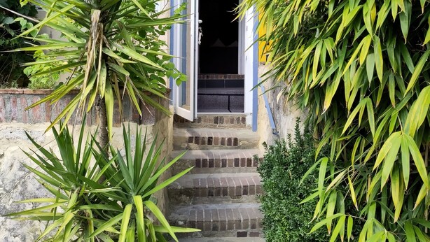 Ein Gebäudeeingang mit einer Treppe, die zu einer Tür führt.