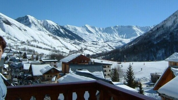 A mountain village with snow-covered houses and a clear view of snow-capped mountains.
