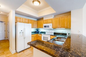 Enjoy cooking in this well-equipped kitchen with a central island, microwave, oven, and stainless steel sink.