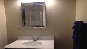 A bathroom with a white sink, a mirror, and a towel rack.