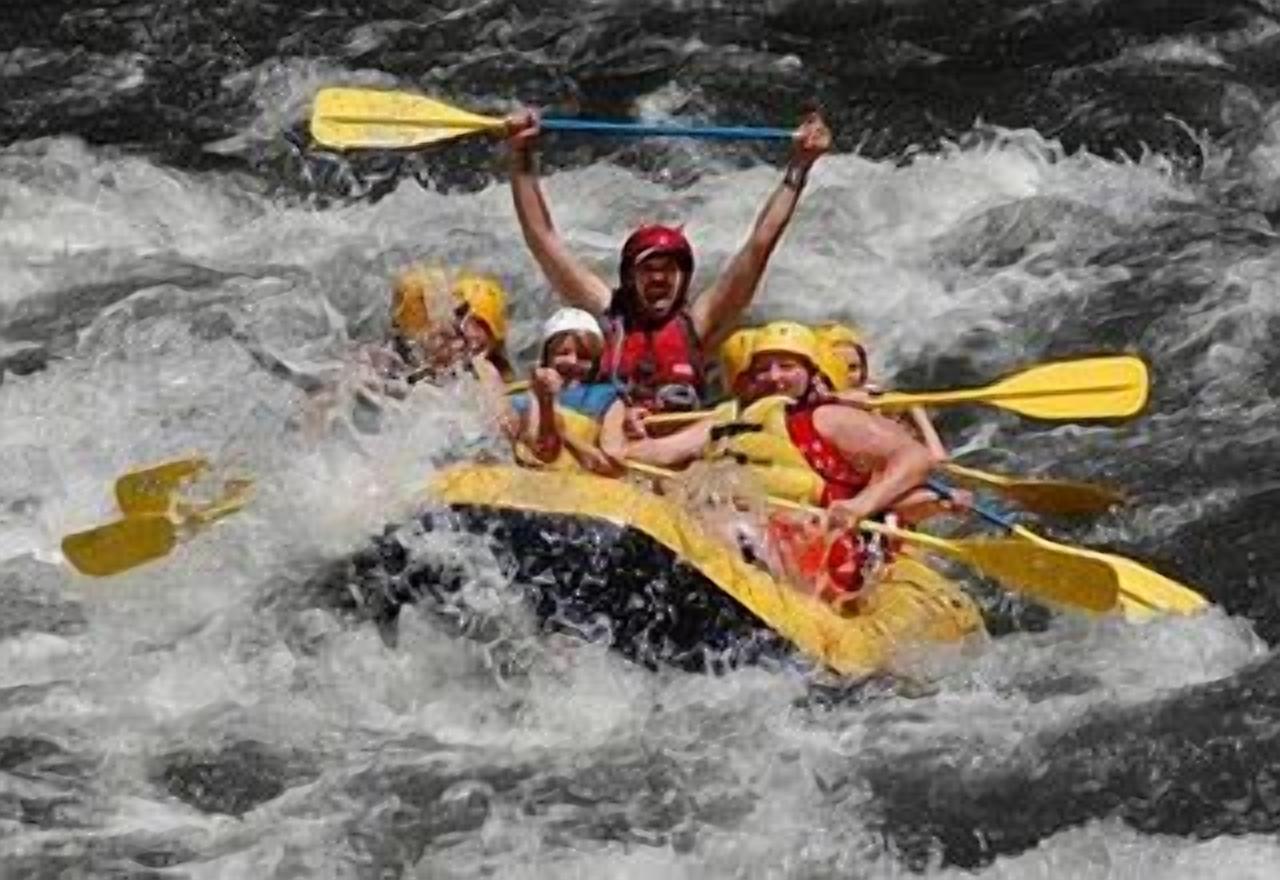 A group of people in a yellow raft navigating through a river.
