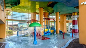Ein Indoor-Wasserpark mit Wasserrutsche, Leuchtturmarchitektur und Wellenbad.
