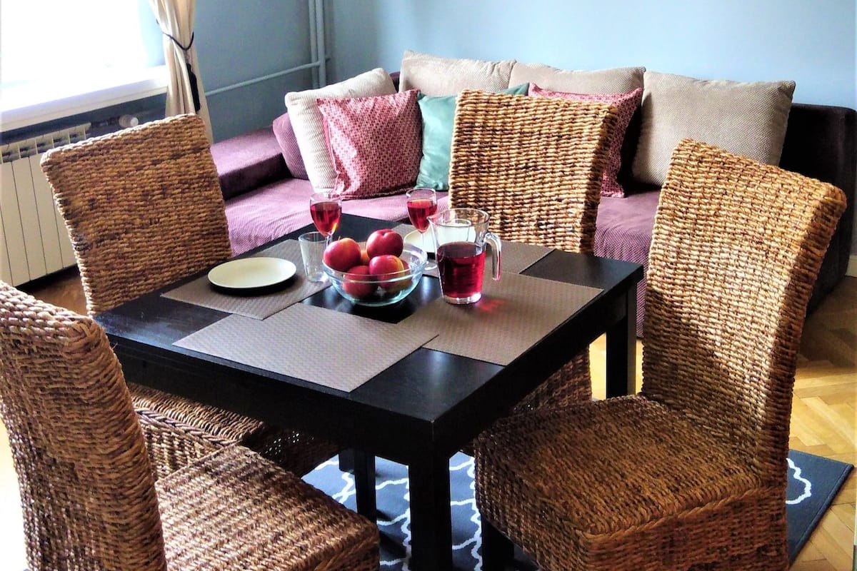 A dining area with a table, chairs, and a chandelier.