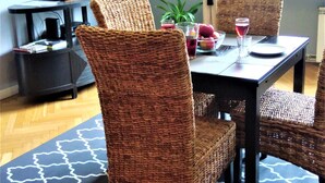 Un comedor con una mesa, sillas y un televisor al fondo.