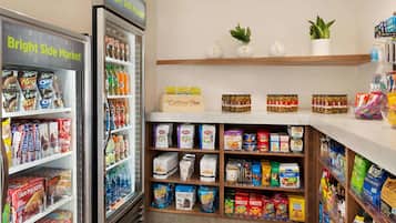 Un negozio di alimentari con sezioni refrigerate, scaffali pieni di snack e una varietà di prodotti confezionati.