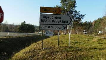 Un panneau indicateur avec des flèches pointant vers « Täljegarden Bed & Breakfast » et « Rum & Stugor ».