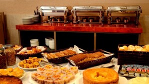 A buffet with various food items and hot beverage dispensers. - Hotel Itaparica (Caruaru)