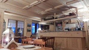 A wooden interior with a dining area, a kitchen counter, and a decorative lantern. - Residence Weissthor (Macugnaga)