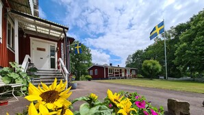 A building with a red exterior and a white door labeled "REC". - Den Sovande Älgen (Markaryd)