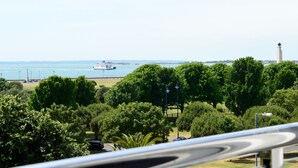 A coastal view with a lighthouse, a boat, and lush greenery. - Q8 Boutique Hotel (Portsmouth)