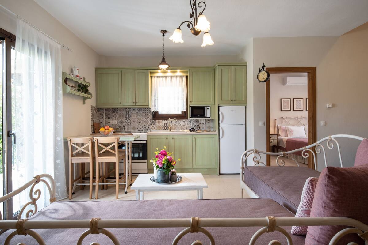 A cozy room with a dining table, chairs, a sofa, and a bed.