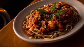 A plate of spaghetti with meatballs and tomato sauce, garnished with a leaf.