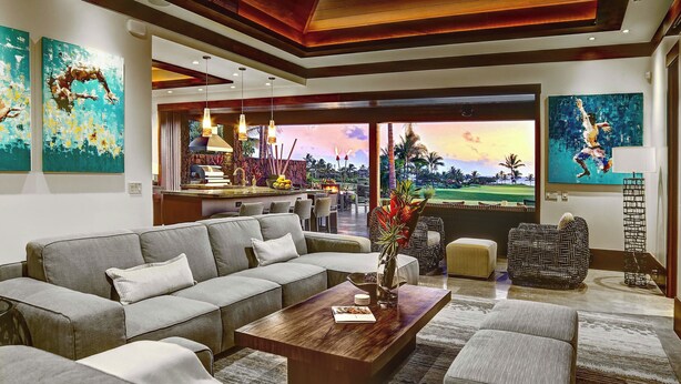 A modern living room with a sectional sofa, a wooden coffee table, and artwork on the walls.
