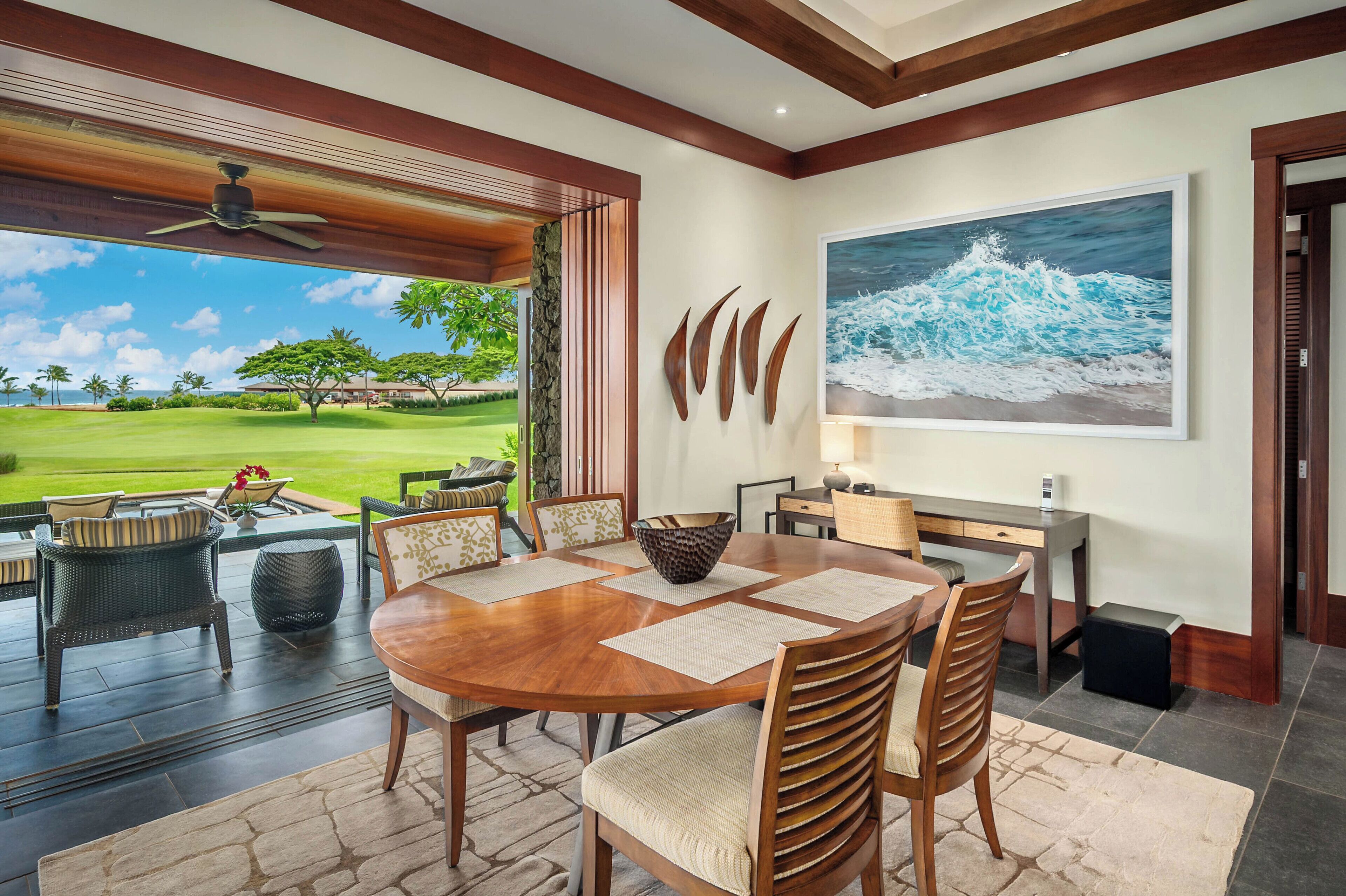 A dining area with a wooden table, chairs, and a view of a golf course.