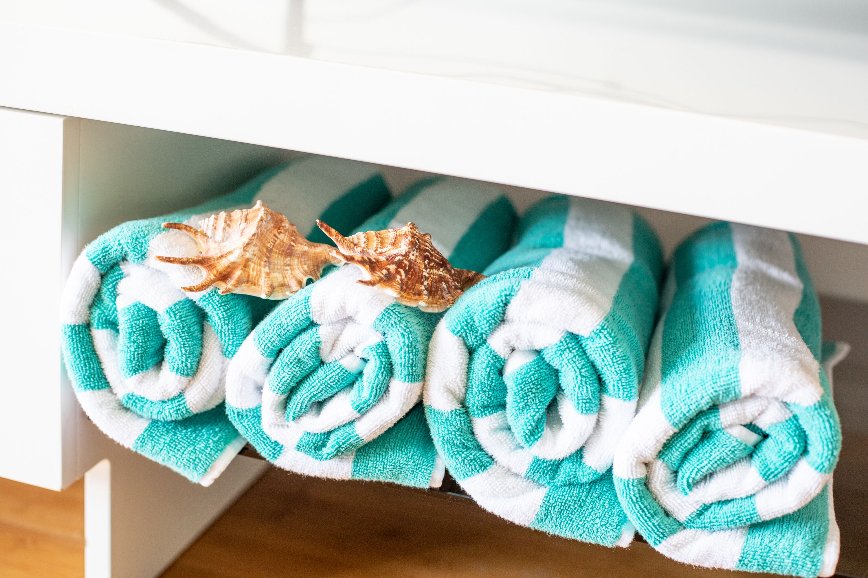 A bathroom with a white sink and a towel rack holding several folded towels.