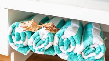 A bathroom with a white sink and a towel rack holding several folded towels.