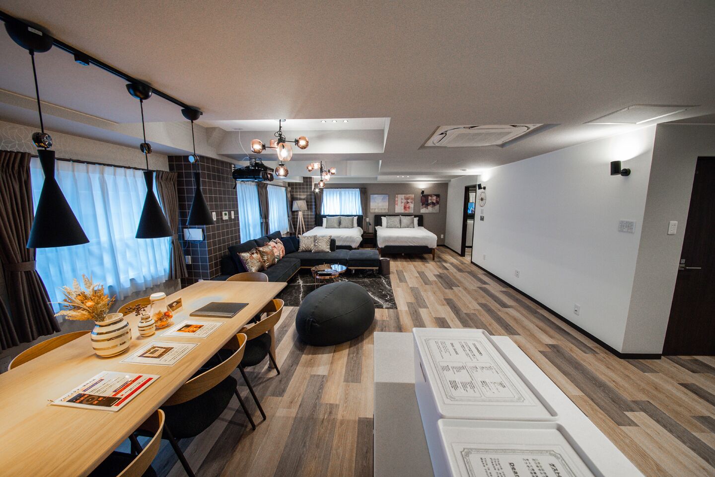 Een moderne hotelkamer met een eethoek, een bank, een bed en een gang.