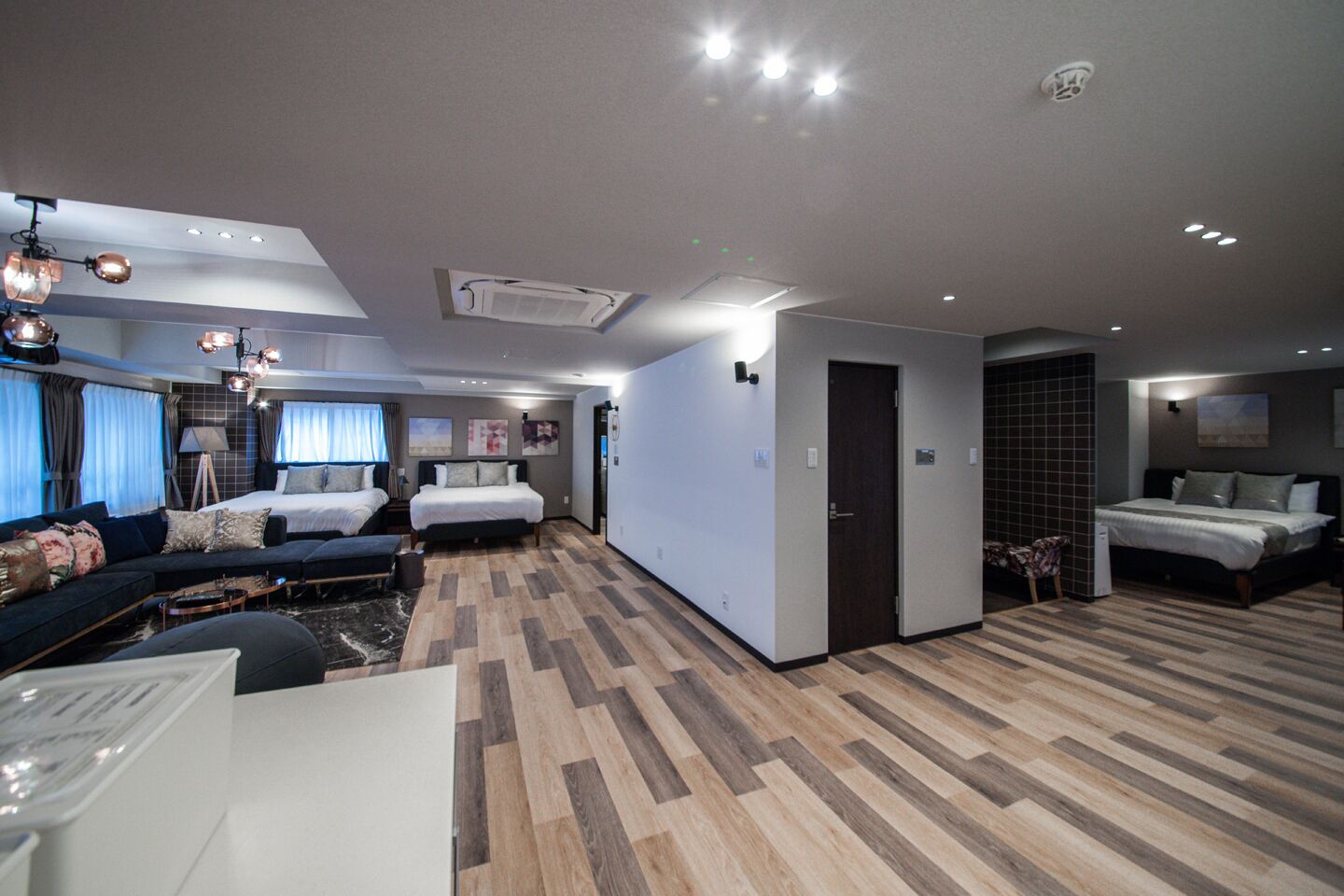 Une chambre d’hôtel moderne équipée d’un grand lit, d’un canapé, d’un bureau et d’un coin repas.