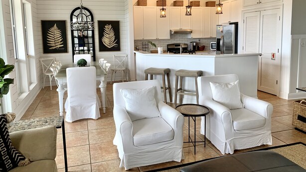 A modern kitchen with white cabinets, a central island, and pendant lighting. - Your Own Private Waterfront Resort! Pool, Hot Tub, Lagoon, Kayaks, Bikes & More! (Gulf Shores)