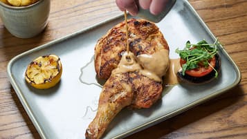A plate with grilled chicken, a slice of lemon, and a small salad.