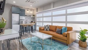 A modern living room with a sofa, coffee table, and dining area. - Walkable South Congress Home + Guest House (Austin)