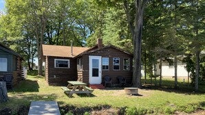 A rustic cabin with a picnic table and a small deck. - Cabin #1 - "Chickagami" (Carp Lake)