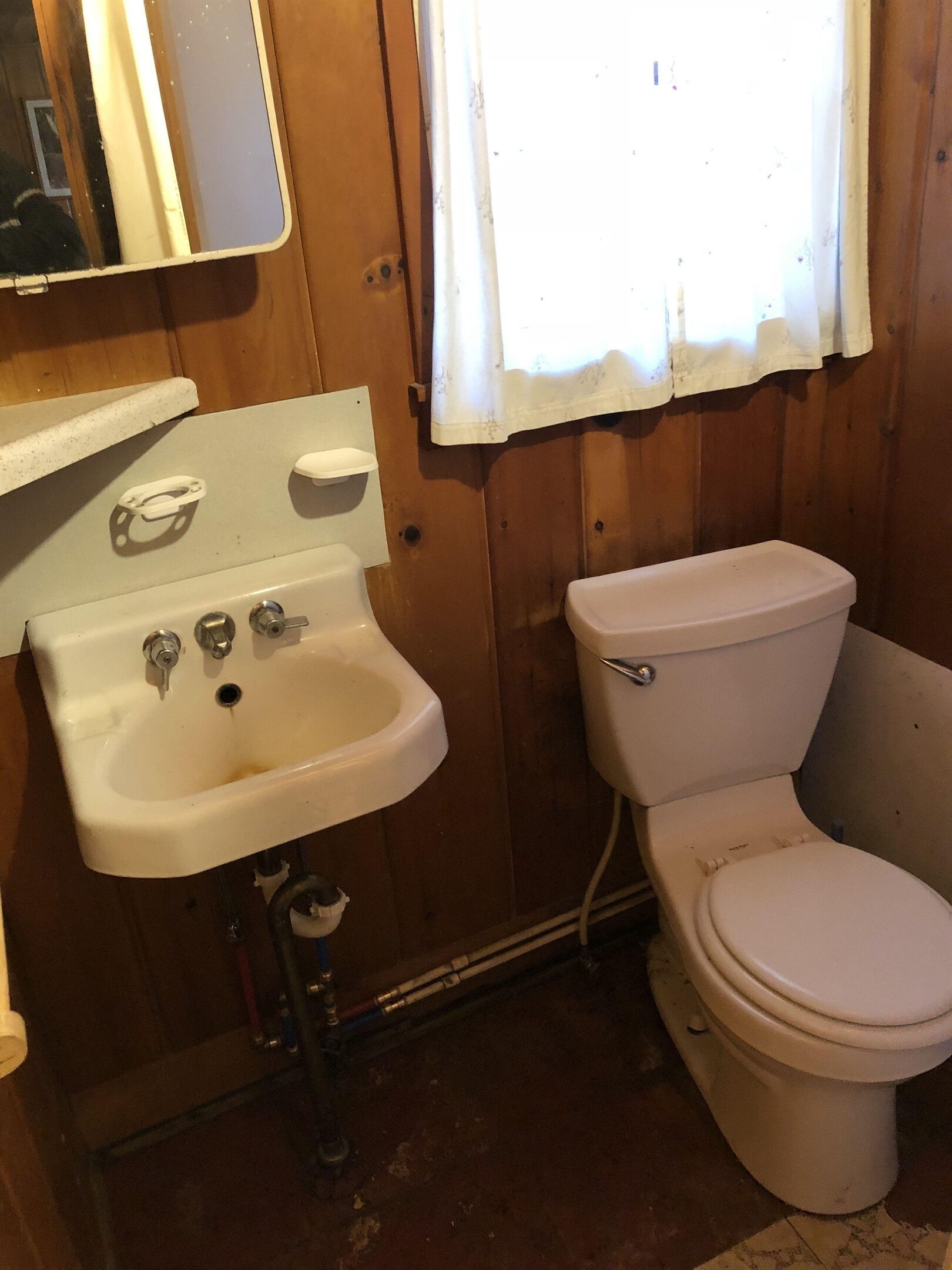 A small bathroom with a white sink, a toilet, and a mirror above the sink.