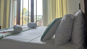Una habitación de hotel con cama, almohadas y cortinas.
