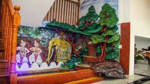 Una escalera con un mural de bailarines, un elefante y una cascada.