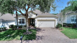 A residential house with a garage, a driveway, and a mailbox. - Luxury 4 Bedroom Florida Holiday Home with Pool & Spa (Davenport)