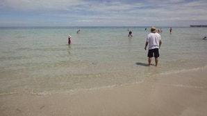 A beach with clear water, people swimming, and a pier in the distance. - Free WIFI **200m to beach** R/C Air in all rooms  (Moonta Bay)
