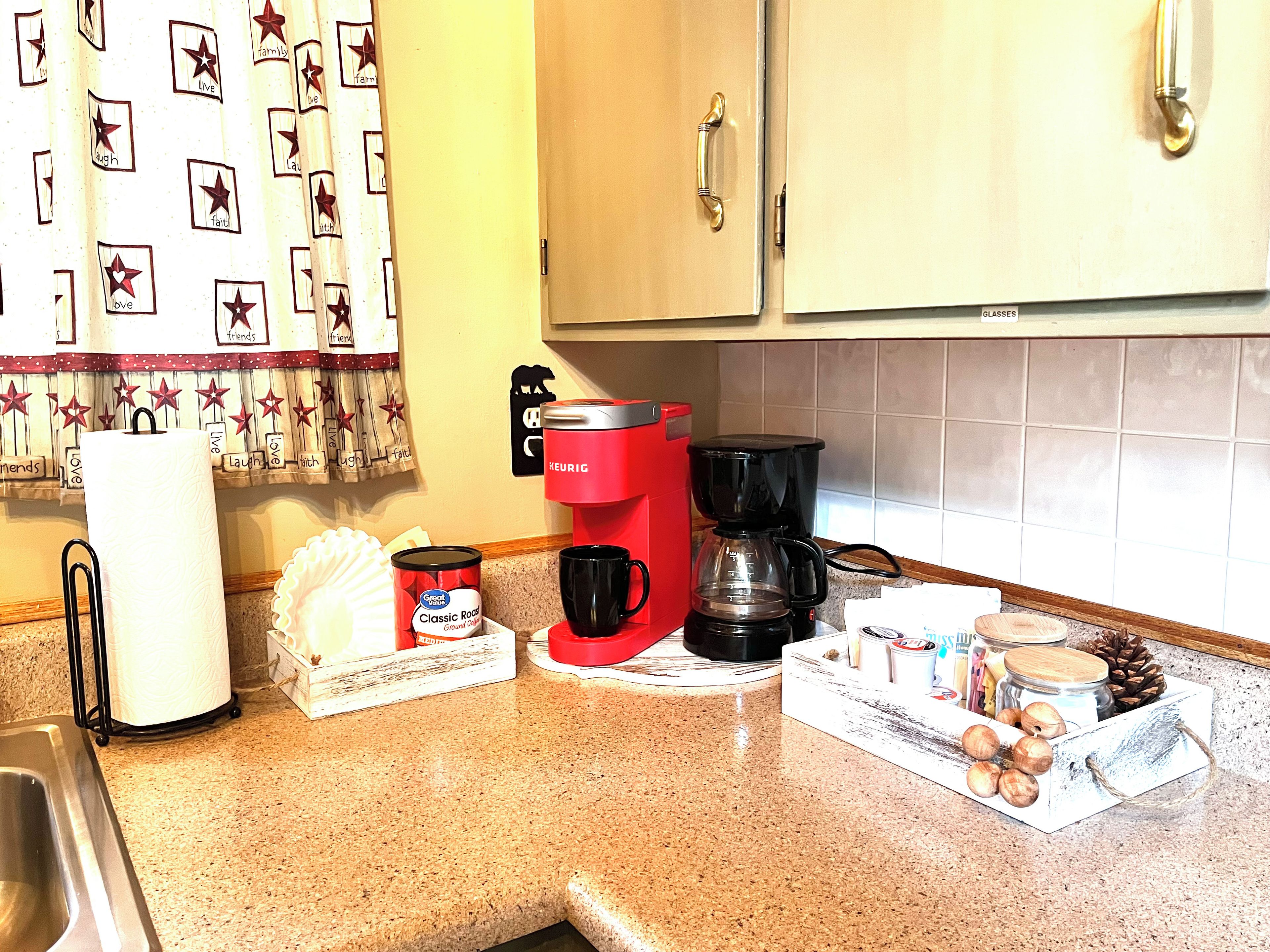 A kitchen counter with a coffee maker, a can of food, and a box of hazelnuts.