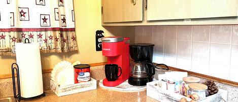 A kitchen counter with a coffee maker, a can of food, and a box of hazelnuts.