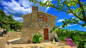 A stone house with a wooden door and window shutters, surrounded by greenery and a clear sky. - Villa Alba with breathtaking view from swiming pool, HEATED POOL, near Motovun (Livade)