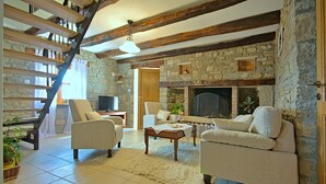 A cozy living room with a stone fireplace, a wooden staircase, and comfortable seating. - Villa Alba with breathtaking view from swiming pool, HEATED POOL, near Motovun (Livade)