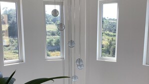 A room with a glass railing, three windows, and hanging spherical lights. - Two Private Pools & Waterfall in a Stunning Portuguese Villa (Armação de Pêra)