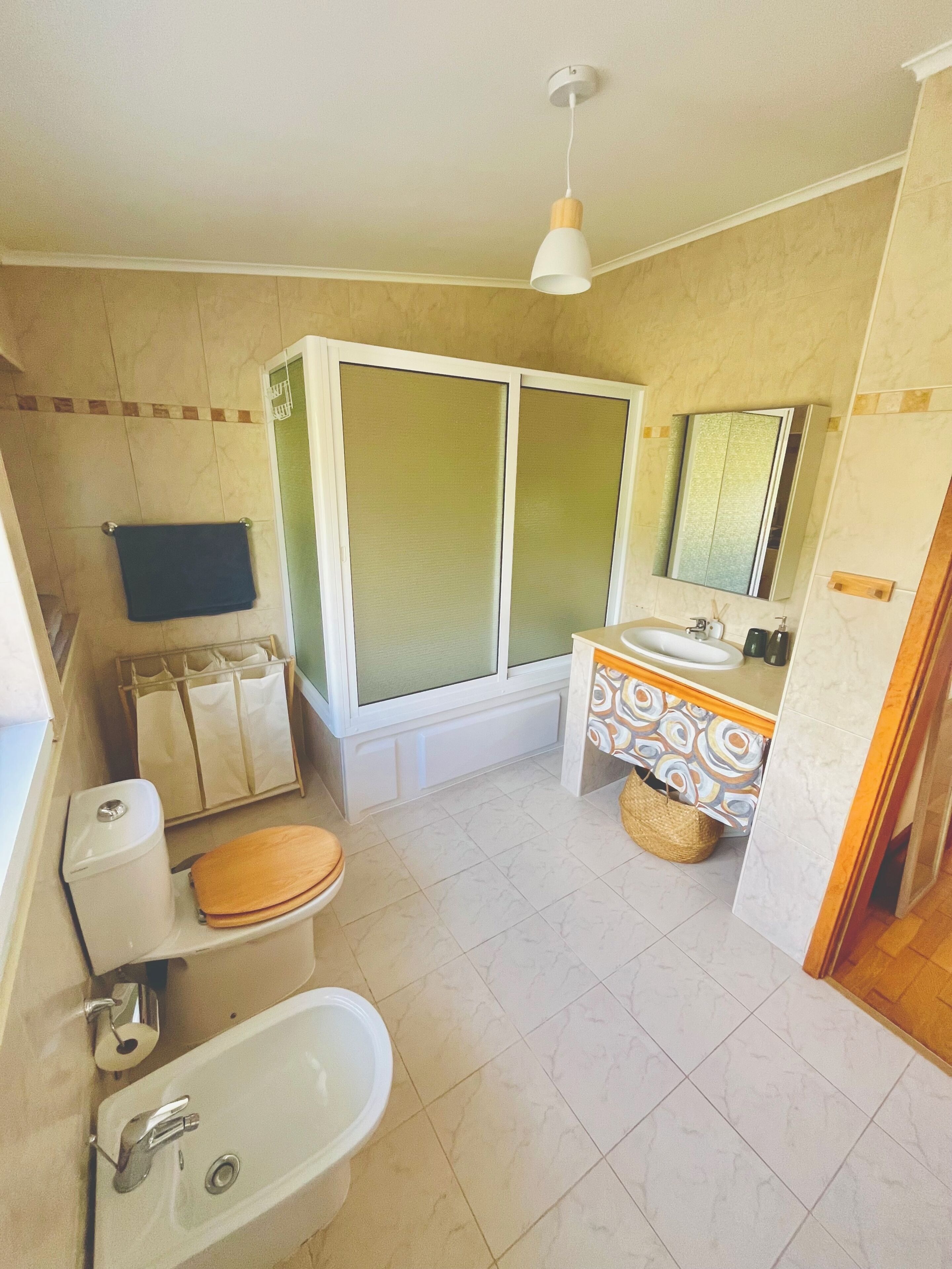 Une salle de bain comprenant des toilettes, un bidet, un lavabo et une douche.