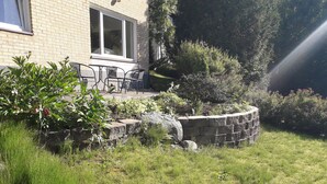 A brick house with a patio area featuring outdoor furniture. - Partille Homestay. 4 rooms with kitchen. (Partille)