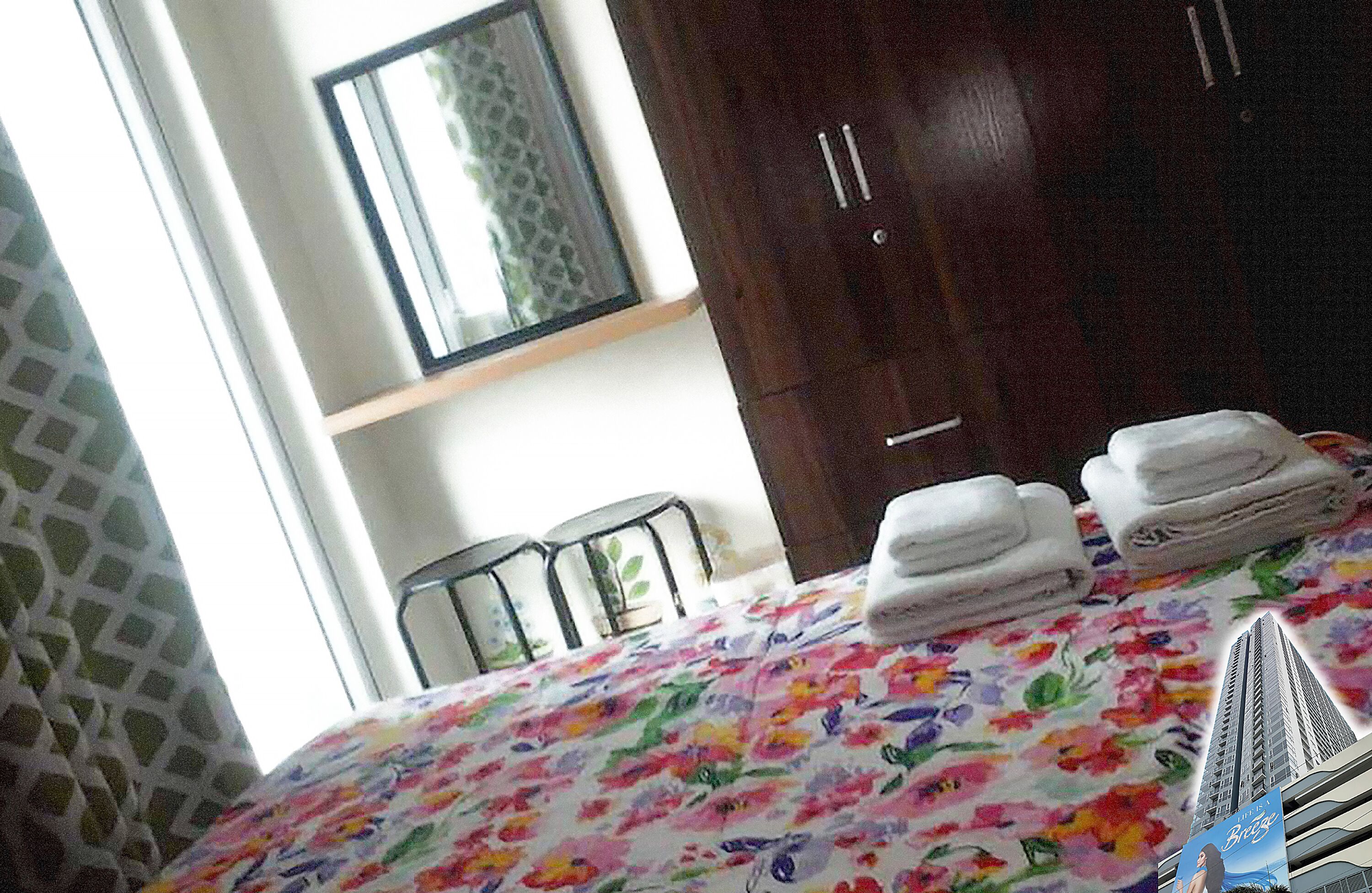 A hotel room with a bed, a wardrobe, and a mirror.