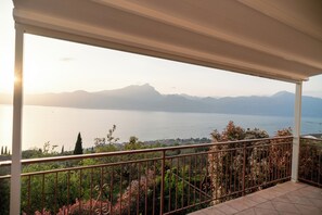 A balcony with a view of a lake and mountains. - BEAUTIFUL LAKE OF GARDA VIEW, surrounded by greenery, WI-FI and AIR CONDITIONING included. (Torri del Benaco (VR))
