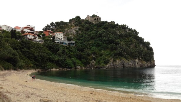 A coastal area with a beach, a castle on a hill, and buildings in the background. - villa anthousa  with excellent view (ANTHUSA)